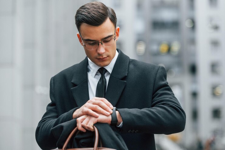 looking-clock-businessman-black-suit-tie-is-outdoors-city_146671-64665.jpg